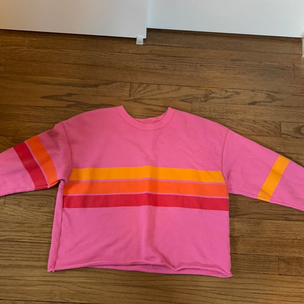 Pink sweater with yellow, orange, and red stripes